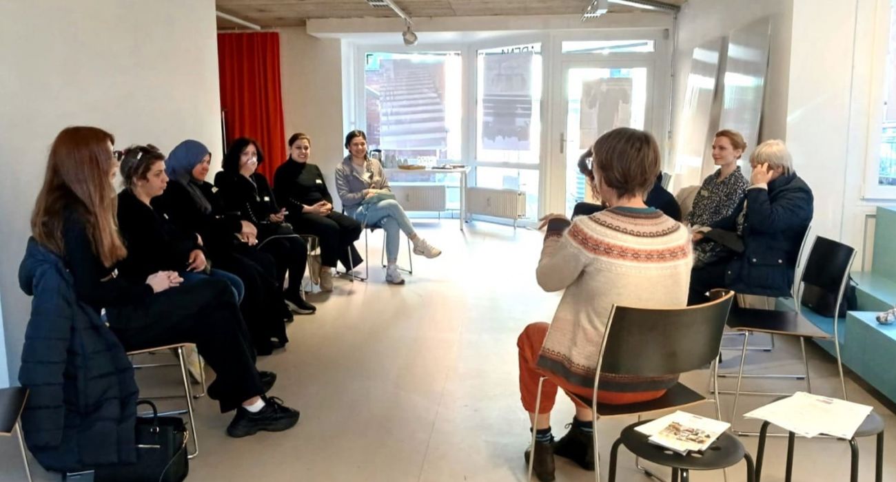 Die Mitmacherinnen sitzen mit der Referentin in einem Kreis.