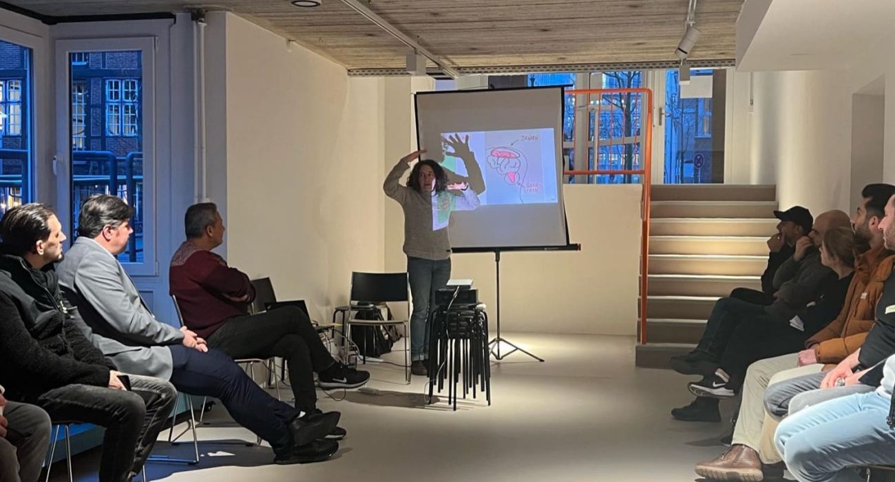 Mareike steht neben einer Leinwand mit einer Präsentation.