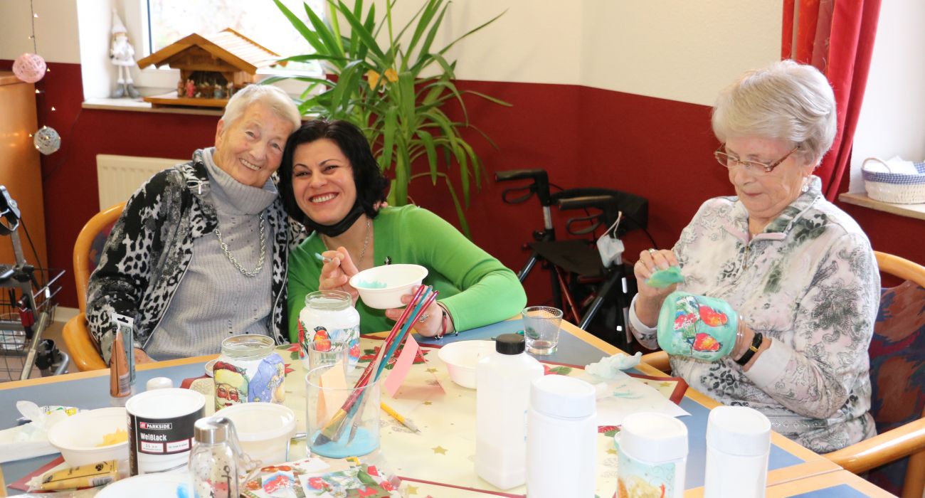 Mariya bastelt im CURA Seniorencentrum Winsen mit Senior*innen